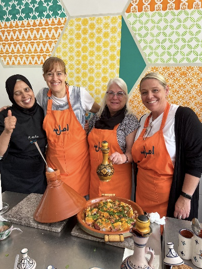 four women with aprons cooking