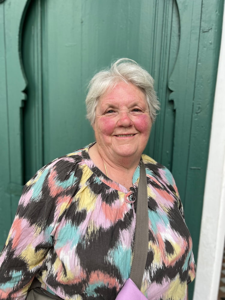 lady standing in front of a green doorway 